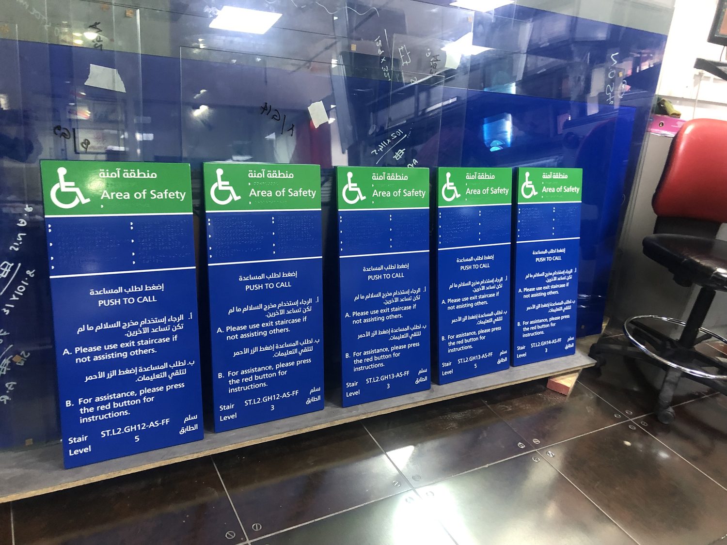 Statutory fire refuge signage with raised braille, printed in English and Arabic